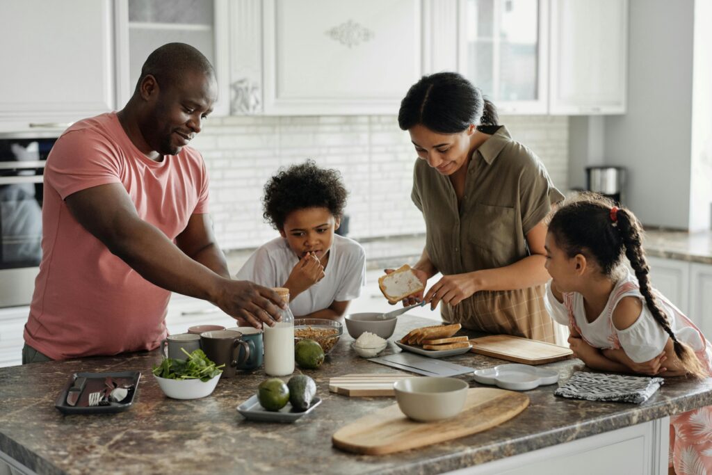 A joyful family enjoys preparing a healthy meal together in their modern kitchen.